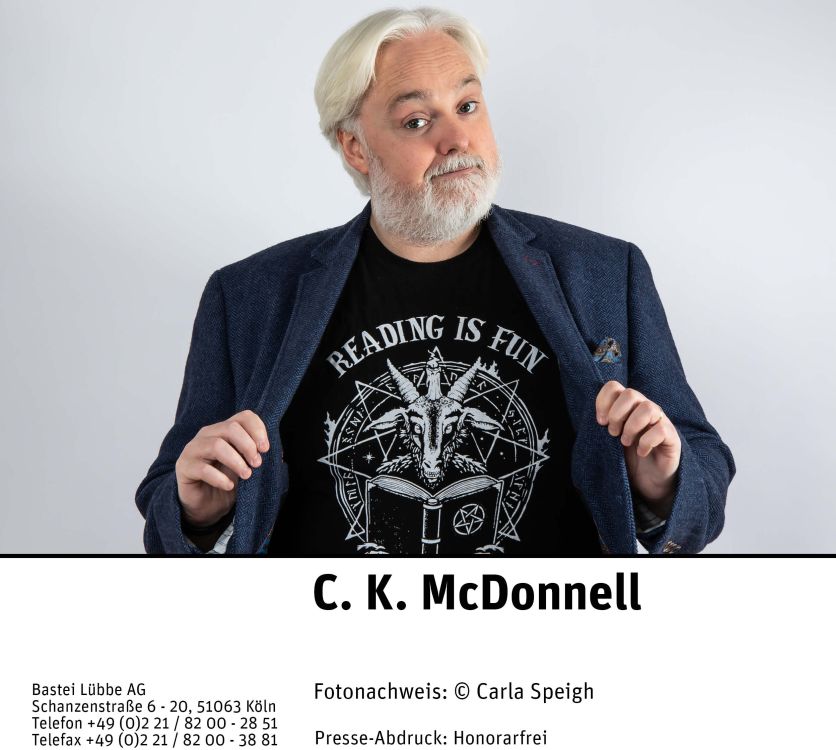 C.K. McDonnell © Carla Speigh/Bastei Lübbe, Portrait, Autor mit schwarzem T-Shirt "eading is fun" und Ziegenbock in Pentagram